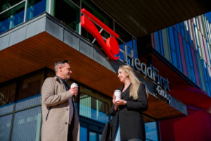 Client and self-employed discuss a contract during a business meeting at HeadFirst Group, with HeadFirst Group's office in the background